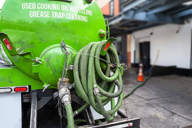 a technician pumping a grease trap in a commercial building in Ardsley, NY